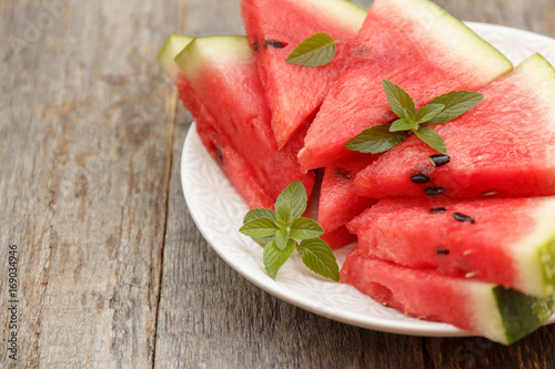 Slices of watermelon on a plate on a wooden background. Selective focus Copy space