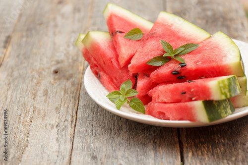 Slices of watermelon on a plate on a wooden background. Selective focus Copy space