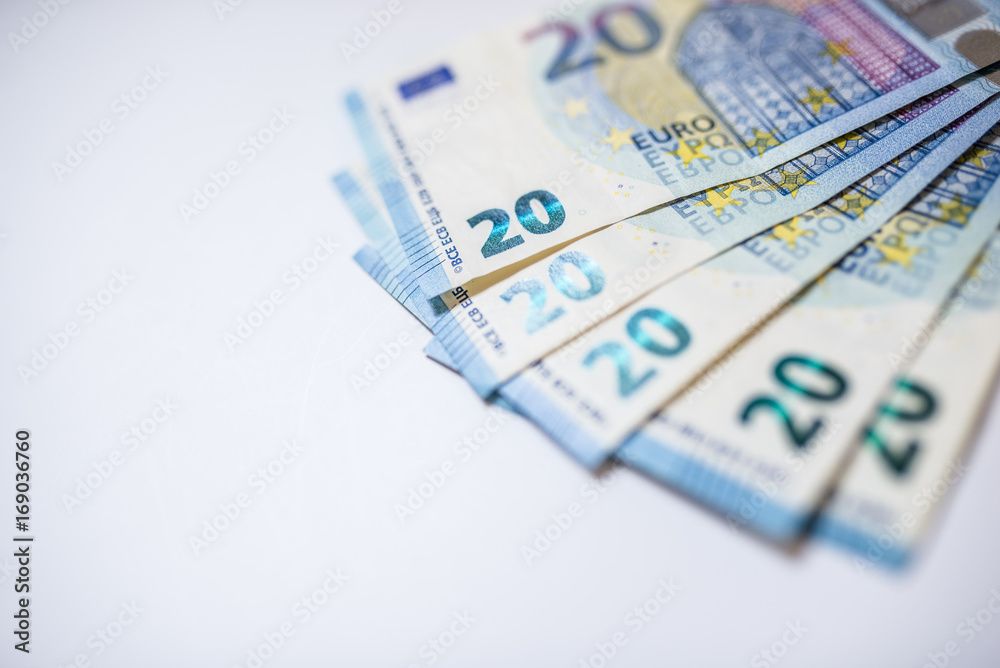Twenty euro notes, spead over a table. Euro money isolated on white background. Twenty euro notes, spead over a table. Euro money isolated on white background.