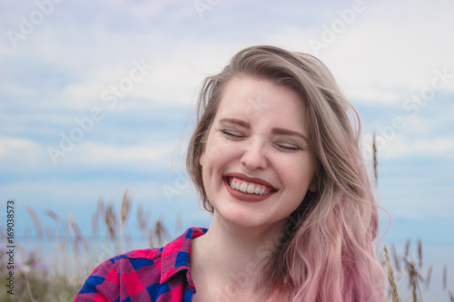 Fashion portrait of happy hipster women laughing. Natural smile. Summer concept, sandy beach, bright sky and sea. Tourism, travel, holidays.