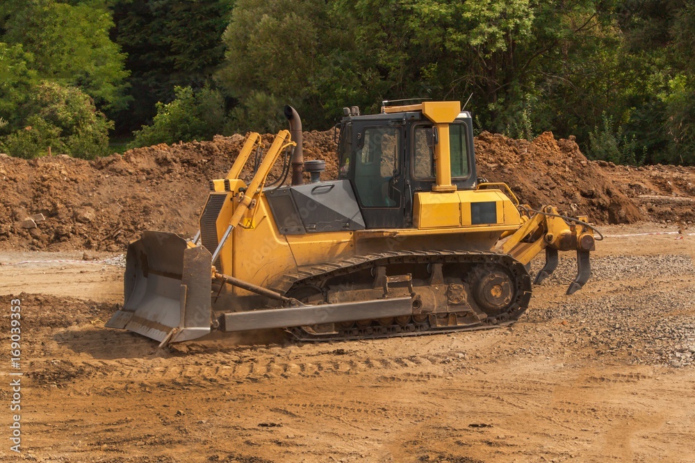 Excavator working on a construction site. Yellow Construction bulldozer at Work. Construction of a new road. Excavator working on a construction site. Yellow Construction bulldozer at Work. Construction of a new road.