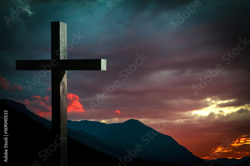scene with Jesus cross on a background with dramatic sky and colorful sunset, sunrise. Jesus Christ wooden cross