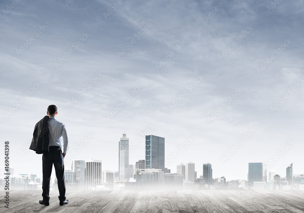Motivation and inspiration concept with modern cityscape and businessman observing it Motivation and inspiration concept with modern cityscape and businessman observing it