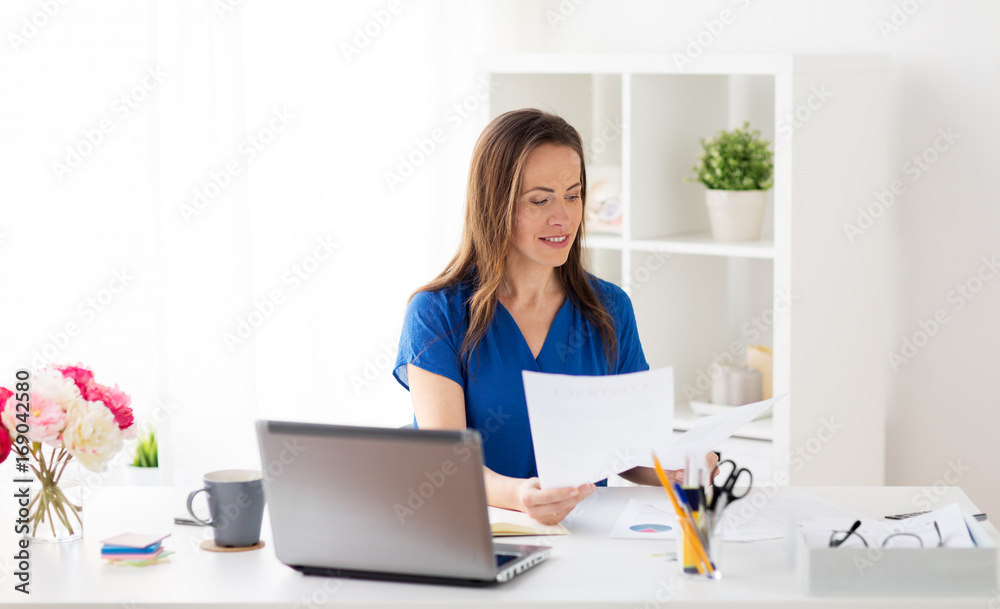 happy woman with papers and laptop at office happy woman with papers and laptop at office
