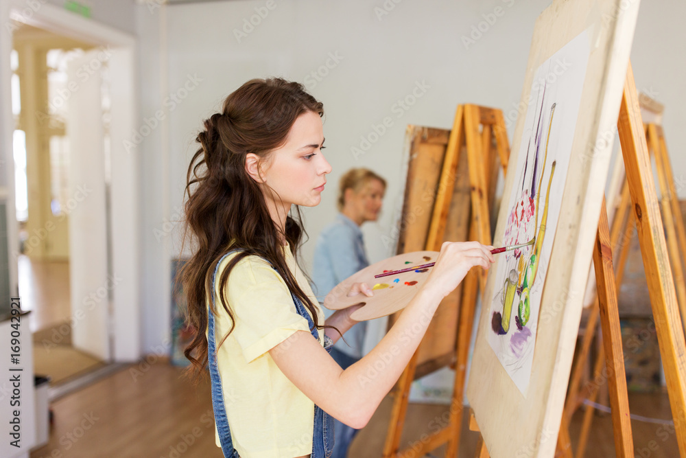 student girl with easel painting at art school student girl with easel painting at art school