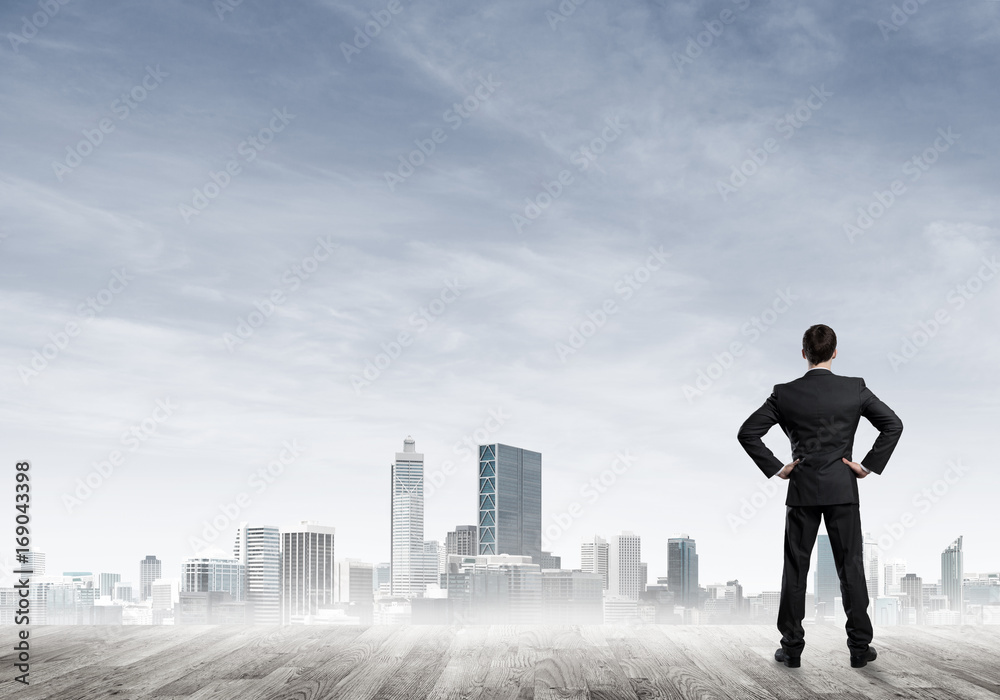 Motivation and inspiration concept with modern cityscape and businessman observing it Motivation and inspiration concept with modern cityscape and businessman observing it