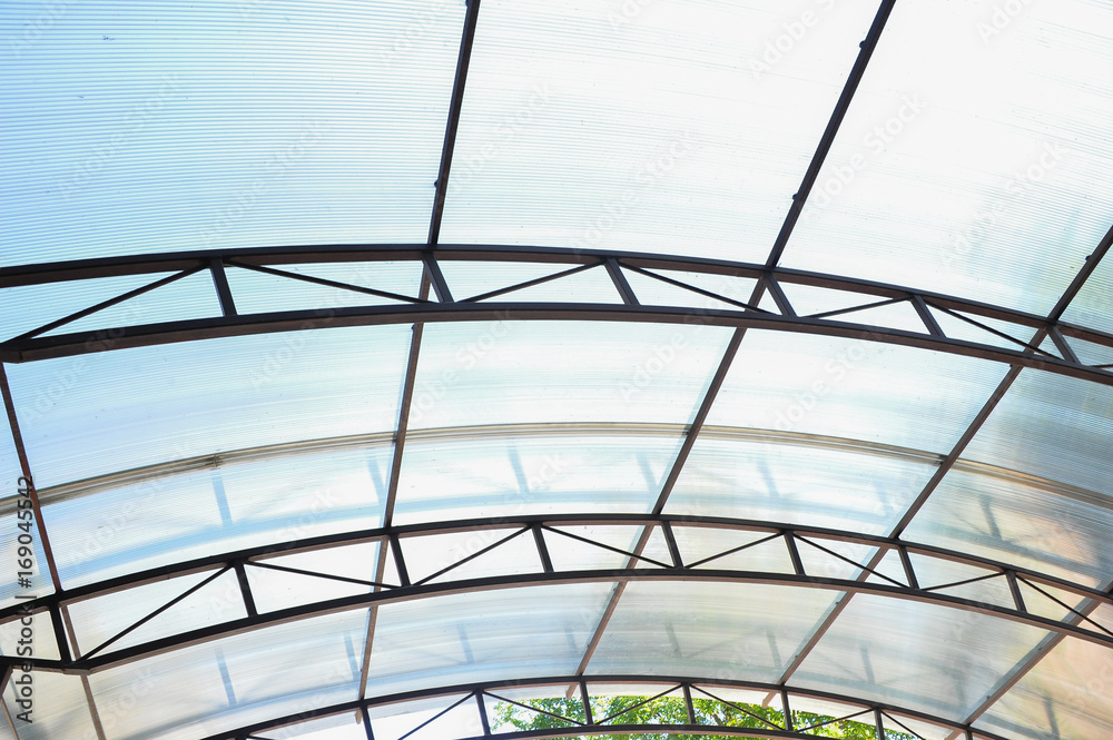 A canopy made of polycarbonate arc against the blue sky. Metal construction.
A canopy made of polycarbonate arc against the blue sky. Metal construction.