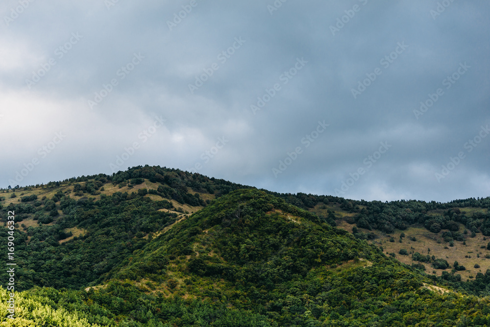 Green mountains and blue cloudy sky