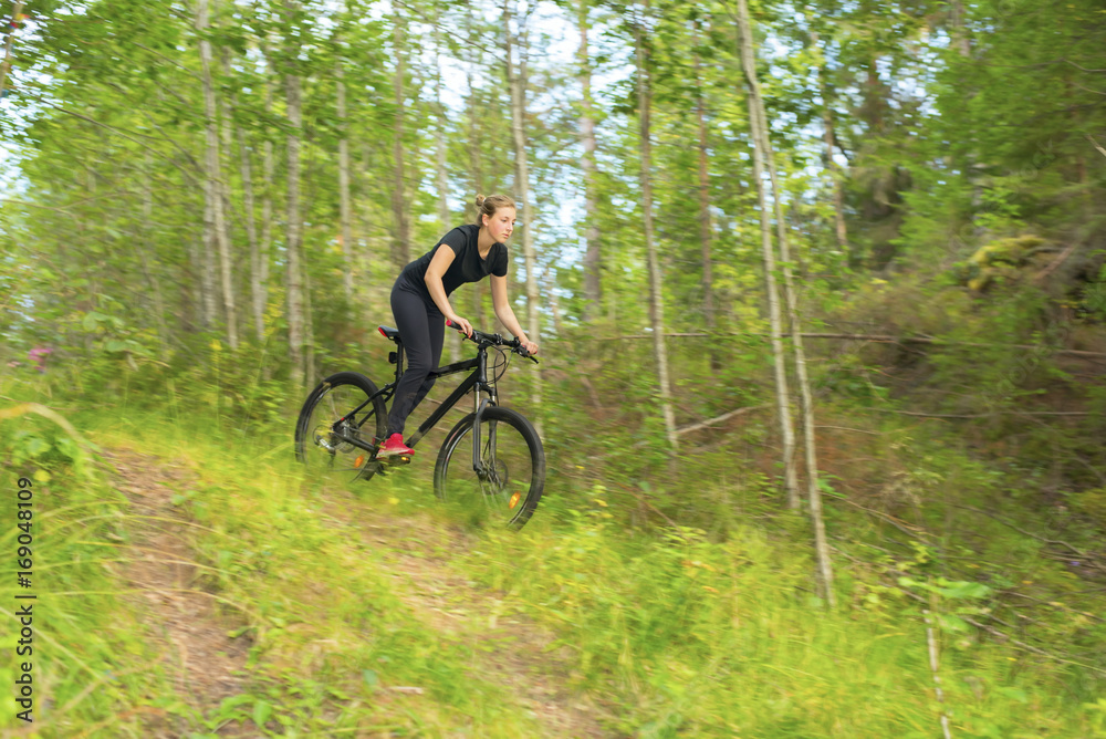 Young girl on mountainbike in the forest Young girl on mountainbike in the forest