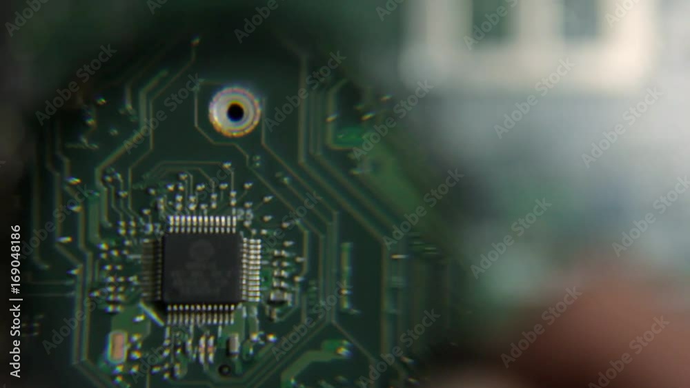 Engineer looking for a problem on motherboard laptop with a magnifying glass Engineer looking for a problem on motherboard laptop with a magnifying glass