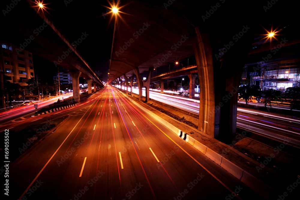 Light trails of fast moving Cars in the City and on the Expressway at midnight