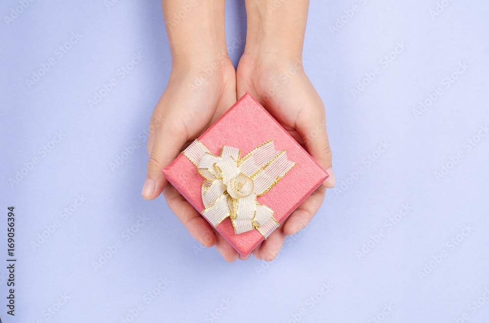 Red gift box in hand for giving in holiday Red gift box in hand for giving in holiday