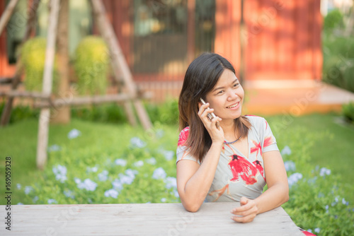 Asian woman using mobile phone in the park
