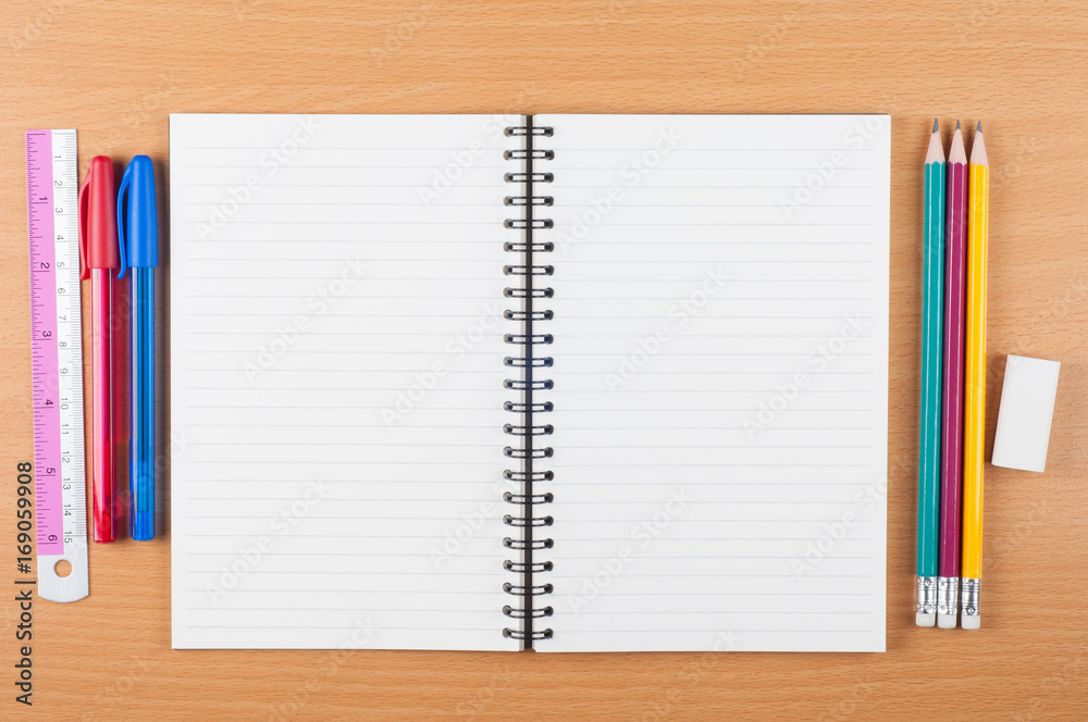 blank open spiral notebook with stationery on wooden desk, top view blank open spiral notebook with stationery on wooden desk, top view