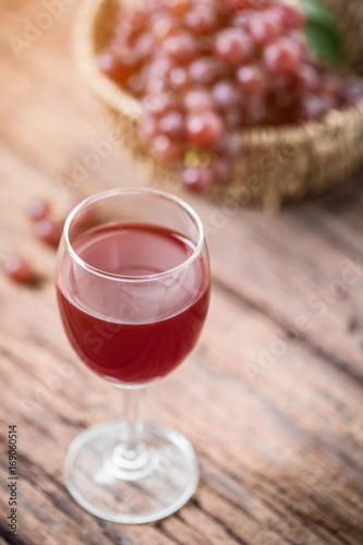 Glass of wine or grape juice and fruit on wooden table