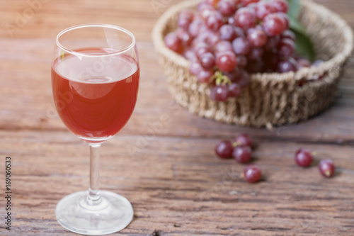 Glass of wine or grape juice and fruit on wooden table