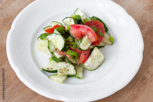 Salad of red tomatoes and cucumbers on a white plate