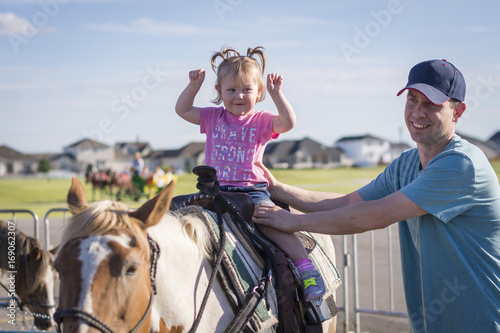 Young girl shows excitement while on her first pony ride © Jason