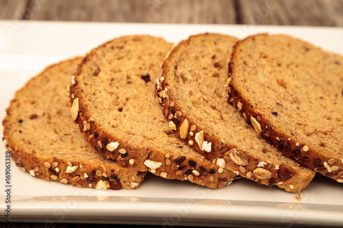 Canvas Print Brown multigrain bread slices on a white plate