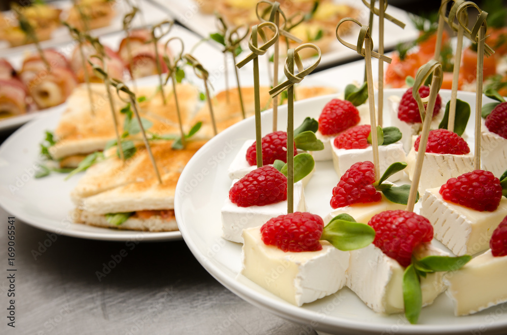 Catering buffet table with a brie cheese skewers with raspberry Catering buffet table with a brie cheese skewers with raspberry