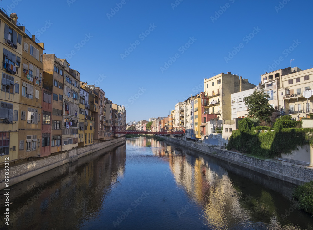 Girona river houses landmark, reflecting water in this famous city close to Barcelona on a blue summer sunny sky