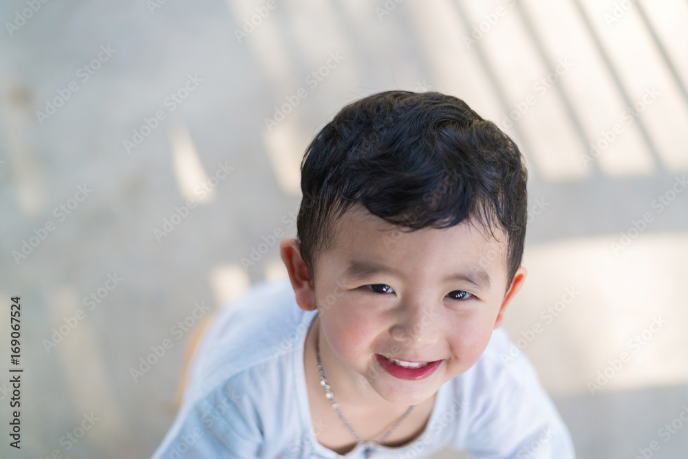 Little Asian kid playing and smiling at the playground under the sunlight in summer, shallow DOF Little Asian kid playing and smiling at the playground under the sunlight in summer, shallow DOF