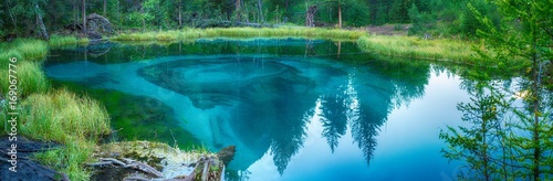 landscape of amazing azure lake surrounded by green forest 