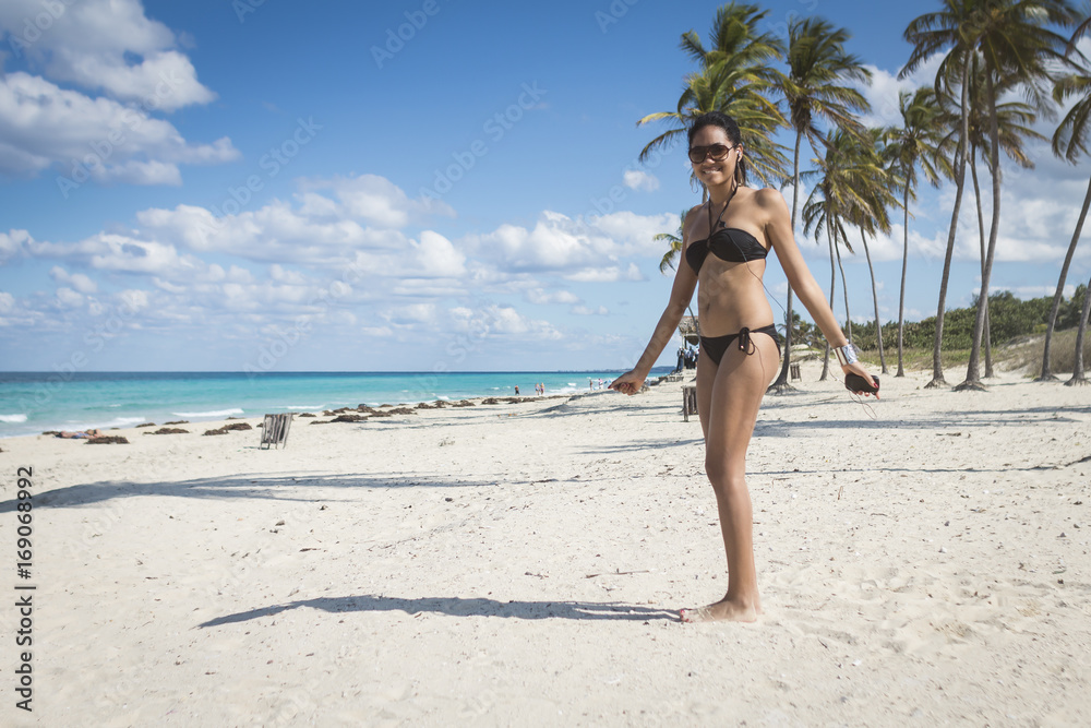 Cuban model dancing on the beach with palms, Cuba Cuban model dancing on the beach with palms, Cuba