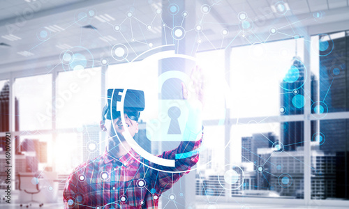 Young man in modern office interior experiencing virtual reality