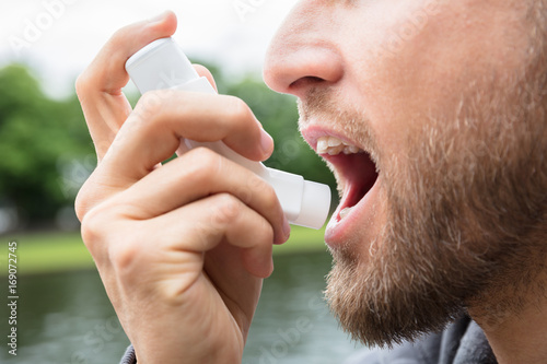 Fototapeta Naklejka Na Ścianę i Meble -  Man Using Asthma Inhaler