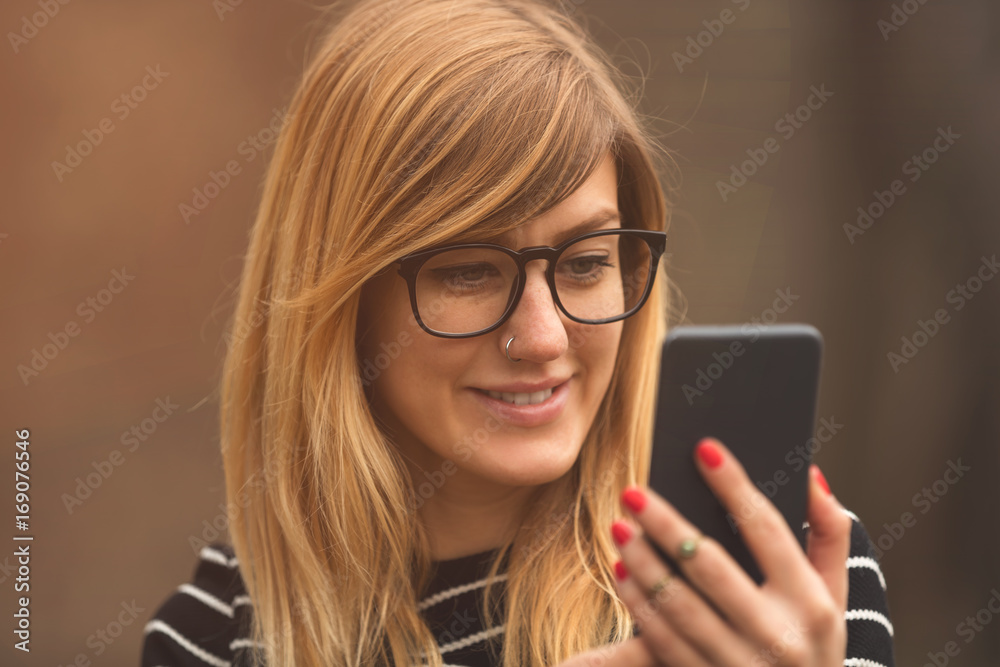 Attractive cute girl using cellphone outdoors. Attractive cute girl using cellphone outdoors.