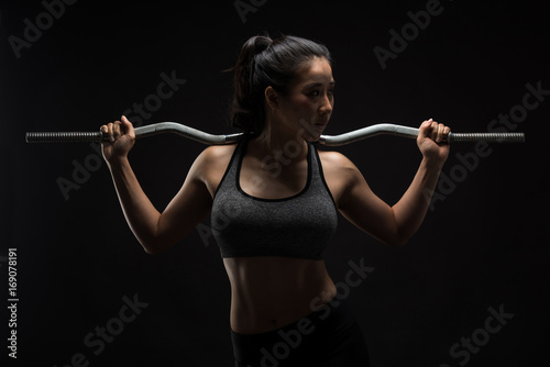 Asian sporty woman with Arms Pain,on a black background,sport,fitness, bodybuilding,healthy and lifestyle concept.