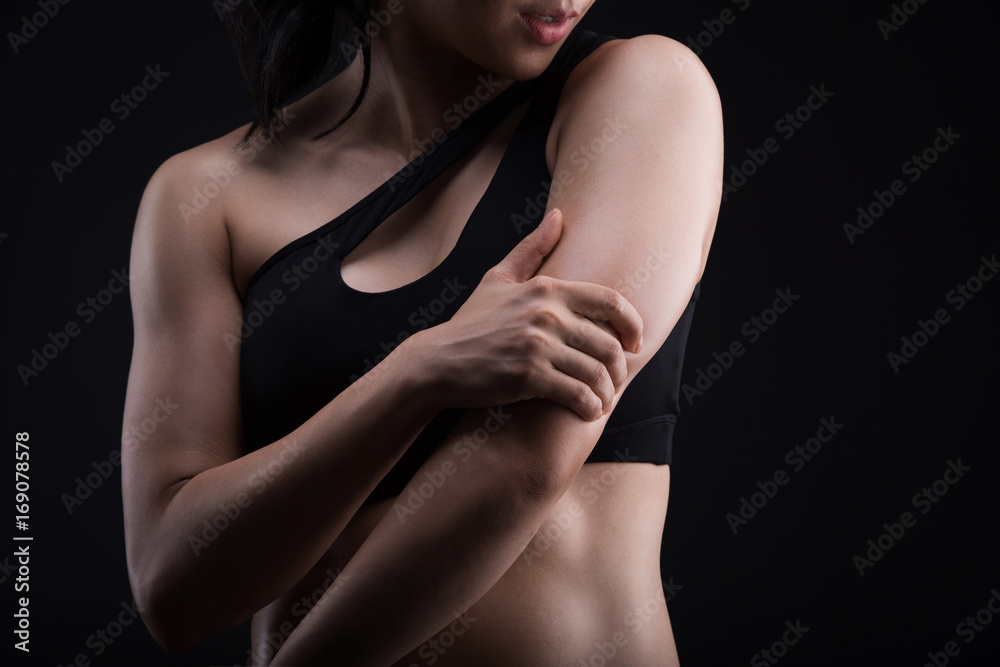Naklejka premium Asian sporty woman with Arms Pain,on a black background,sport,fitness, bodybuilding,healthy and lifestyle concept.
