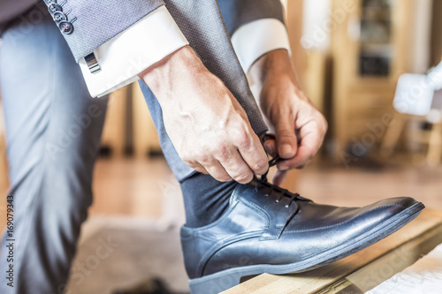 Bräutigam auf Hochzeit bindet sich die Schuhe, Detail