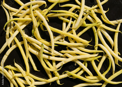 Fresh raw yellow beans on dark background.