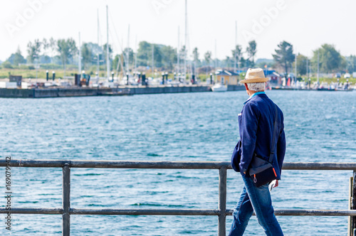 Mann mit Hut geht spazieren an der Ostsee