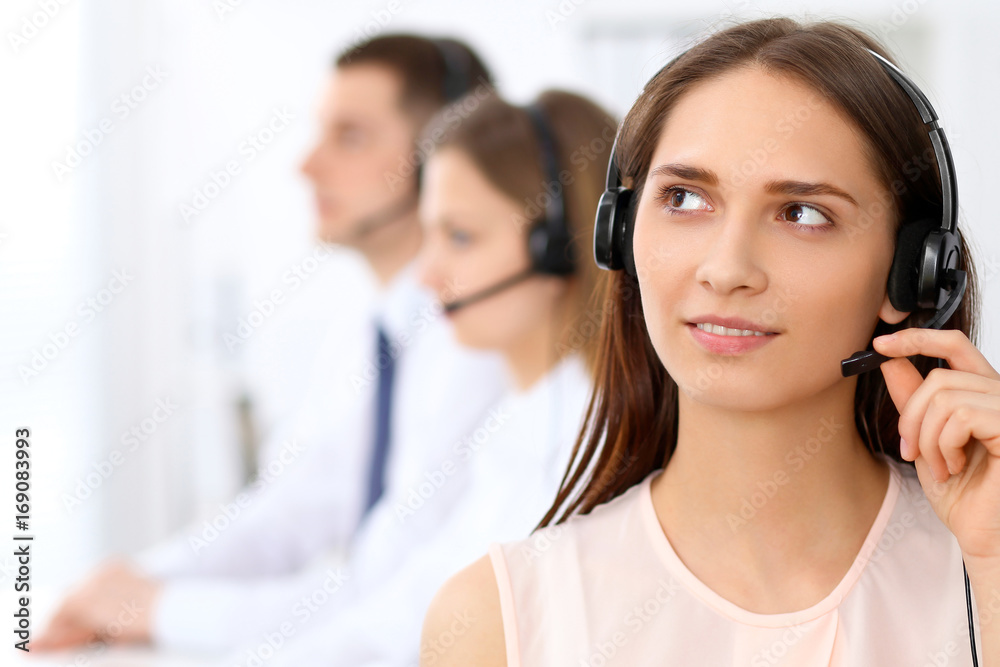 Call center operators. Focus at young beautiful business woman in headset Call center operators. Focus at young beautiful business woman in headset