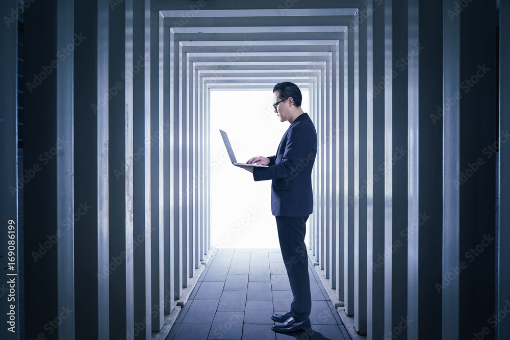 Businessman using laptop with Line-shaped corridors background , night scene . Businessman using laptop with Line-shaped corridors background , night scene .