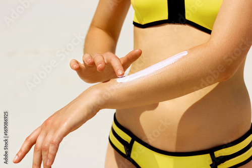 Closeup on female hand applying sun block creme on hand at the beach.Skin Care..Sun protection sun cream.