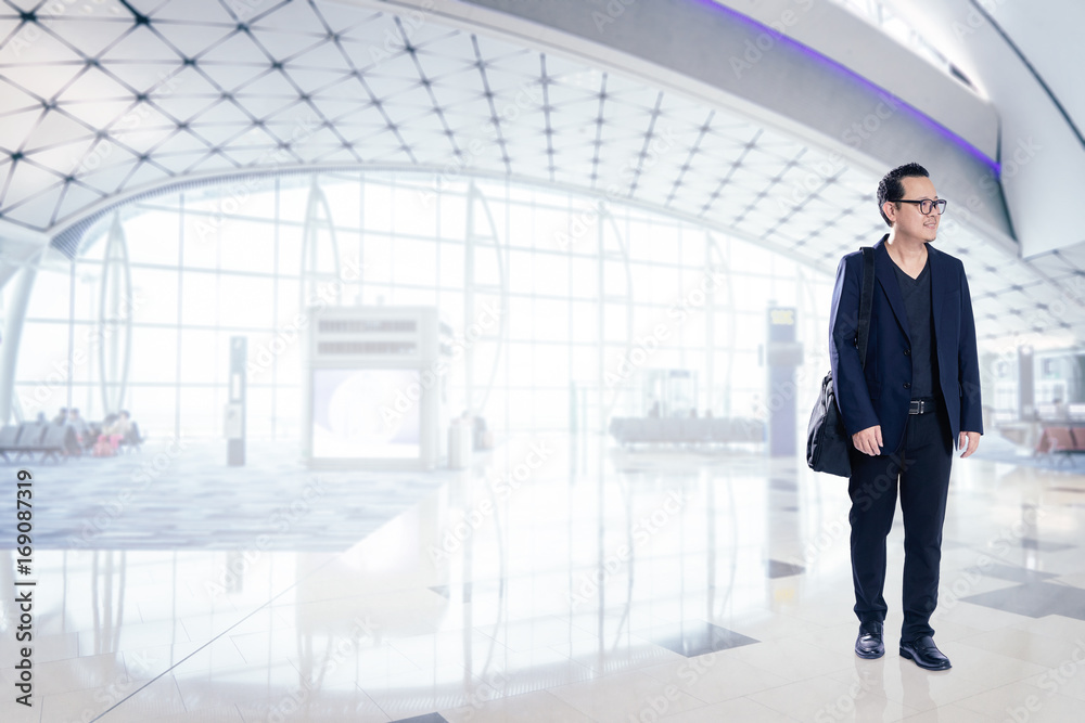 Young business man smiling happy inside  airport waiting hall  .