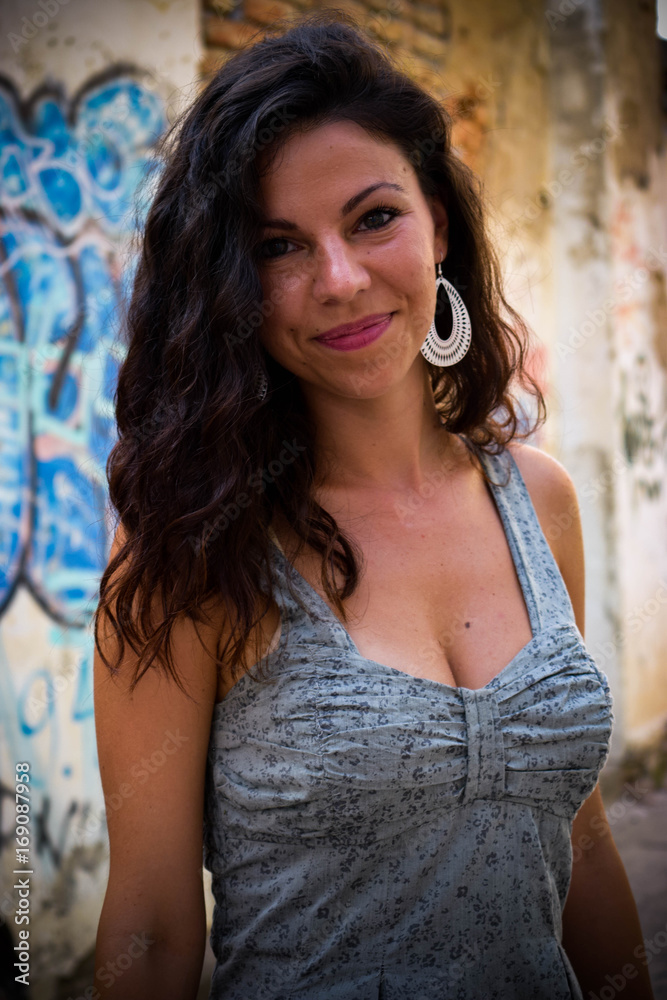 Fototapeta premium Beautiful girl posing beside a rustic wall
