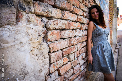 Fototapeta Naklejka Na Ścianę i Meble -  Beautiful girl posing beside a rustic wall