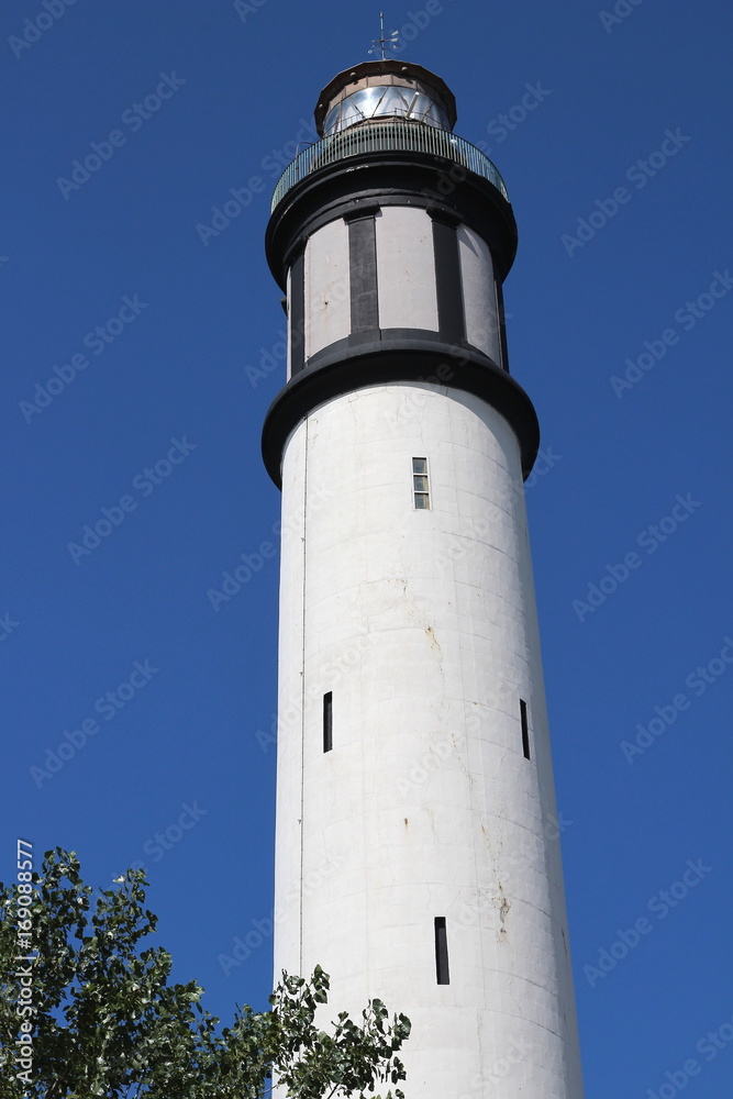 haut d'un phare blanc sur fond de ciel bleu sans nuage