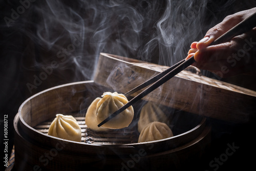 Boiled and hot chinese dumplings on black background