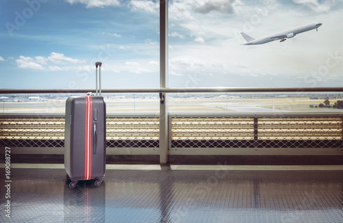 Photography Suitcases in airport departure lounge, airplane in background, summer vacation concept, traveler suitcases in airport terminal waiting area