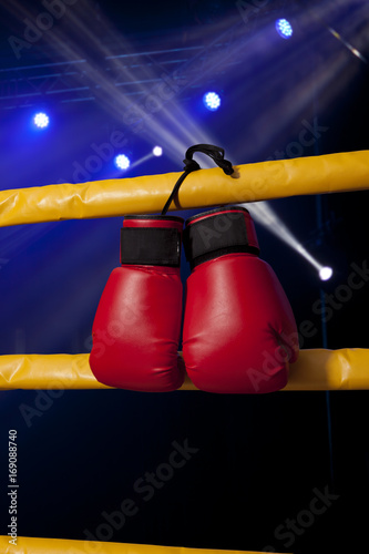 Red boxing gloves hangs off the boxing ring