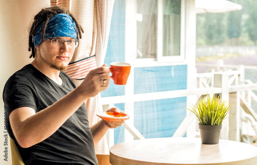 a man with dreadlocks is drinking coffee at home a man with dreadlocks is drinking coffee at home
