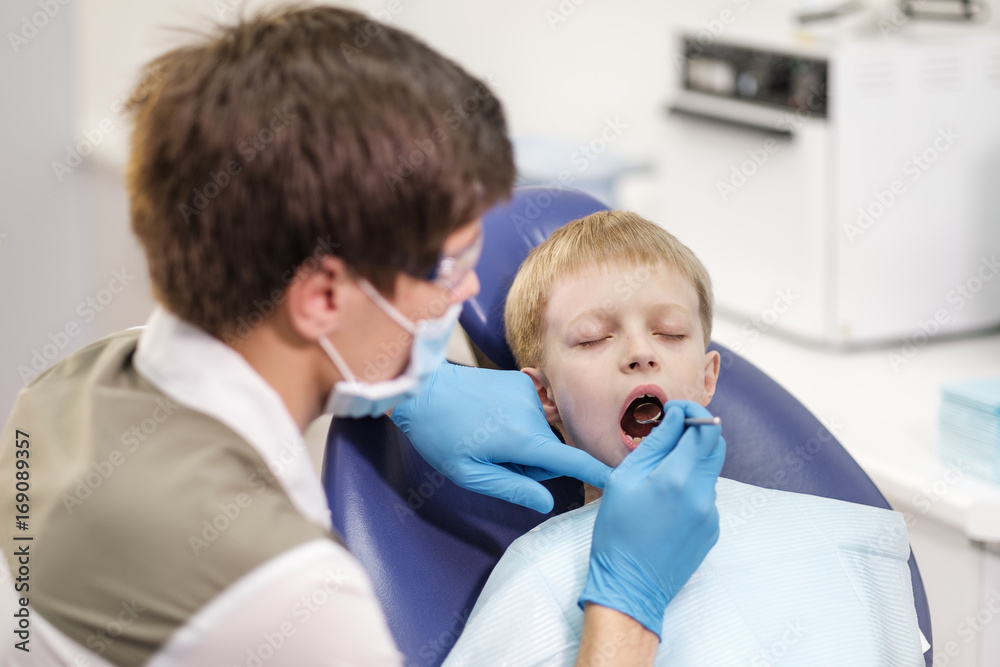 Male dentist examines the teeth of the patient cheerful boy. Male dentist examines the teeth of the patient cheerful boy.