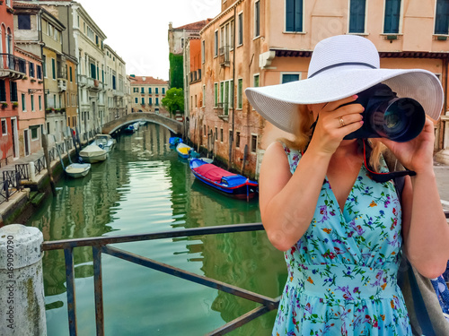 Close-up portrait of attractive woman taking pictures with her camera while discovering Venice. © Angelov