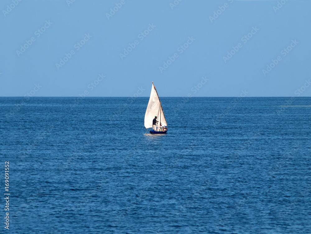 Fishermen on a small boat in the middle of the ocean Stock Photo